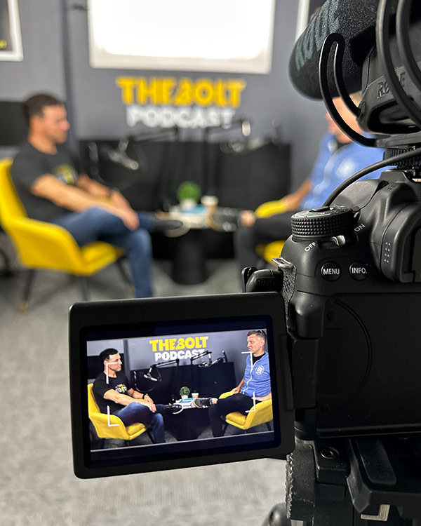 podcast studio, camera, guests out of focus